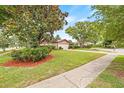 Landscaped front yard with mature trees enhancing the curb appeal at 1880 Oak Bark Ct, Clearwater, FL 33763
