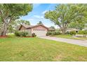 Single-story home featuring a well-maintained lawn and landscape at 1880 Oak Bark Ct, Clearwater, FL 33763
