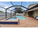 A screened in pool and hot tub on a brick patio perfect for relaxation and entertainment at 2330 Lawrence Hall St, Ruskin, FL 33570