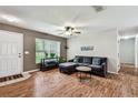 Inviting living room with a comfortable sectional sofa, a neutral color palette, and natural light streaming through the window at 25623 Inkwood Pl, Wesley Chapel, FL 33544