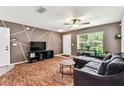 Stylish living room features a geometric accent wall, a comfortable couch, and plenty of natural light at 25623 Inkwood Pl, Wesley Chapel, FL 33544
