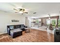 Open-concept living space flows into the kitchen, featuring wood floors and a ceiling fan, perfect for entertaining at 25623 Inkwood Pl, Wesley Chapel, FL 33544