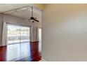 Open living area with wood floors, ceiling fan, vaulted ceilings and a sliding door to the balcony at 2932 Lichen Ln # D, Clearwater, FL 33760