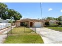 Inviting single-story home featuring a well-kept lawn, stone accents, and attached garage at 4208 W Flora St, Tampa, FL 33614