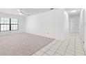 Spacious living room featuring neutral carpet, bright walls, and a window offering natural light at 4208 W Flora St, Tampa, FL 33614