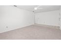 Clean living space with carpeted flooring, a ceiling fan, and a neutral color scheme at 4208 W Flora St, Tampa, FL 33614
