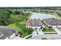 Aerial view of a lakeside home with manicured lawn and three-car garage in a gated community at 4583 Barletta Ct, Wesley Chapel, FL 33543