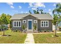Inviting home exterior featuring a brick pathway, landscaped yard, and a charming blue front door at 475 28Th N Ave, St Petersburg, FL 33704