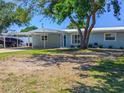 Charming single-story home featuring an attached carport and mature landscaping at 489 Fox Run Trl, Apollo Beach, FL 33572