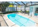 A large screened pool is surrounded by a patio table, and turf, with a fence at 489 Fox Run Trl, Apollo Beach, FL 33572