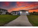 Charming single Gathering home with a blue front door, lush lawn, and a two car garage at 4976 Cedarbrook Ln, Hernando Beach, FL 34607