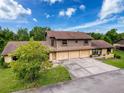 A charming home with a three-car garage and a well-maintained front yard at 507 E Curlew Pl, Tarpon Springs, FL 34689