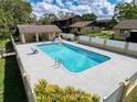 A serene pool area with lounge chairs and a covered patio for relaxation at 507 E Curlew Pl, Tarpon Springs, FL 34689
