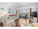 Inviting living area with hardwood floors, ceiling fan and a sliding glass door to the patio at 5157 Silent Loop # 208, New Port Richey, FL 34652