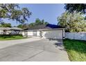 This home features a well-maintained lawn and an attached two-car garage, set under a clear, sunny sky at 5435 Birchwood Rd, Spring Hill, FL 34608