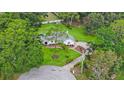 Expansive aerial view of a lovely white home with beautiful landscaping and a circular driveway at 5933 Carina Trce, Wesley Chapel, FL 33545