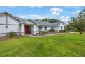 Beautifully landscaped home with a well-maintained lawn and an inviting red front door at 5933 Carina Trce, Wesley Chapel, FL 33545