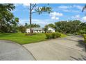 Charming single-story home with a well-manicured lawn, mature landscaping, and a long driveway, creating an inviting curb appeal at 5933 Carina Trce, Wesley Chapel, FL 33545
