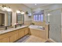 Bright bathroom featuring a soaking tub, double vanity, and separate shower with decorative glass door at 611 Robinson Oaks Ln, Plant City, FL 33567