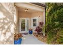 Inviting front entrance featuring double glass doors, potted plants, and a small decorative rock garden at 6627 Date Palm S Ave, St Petersburg, FL 33707