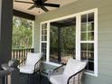 Inviting porch with ceiling fan, large windows, and seating provides the perfect spot to relax at 7152 Sandy Ln, Wesley Chapel, FL 33544