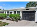 A beautiful close-up shot of a single-story home with dark garage door, black fixtures and bright white trim at 7304 Lakeside Blvd, Tampa, FL 33614