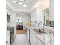 Bright kitchen with stainless steel appliances, sleek countertops, ample natural light, and stylish modern lighting at 7360 Ulmerton Rd # 18A, Largo, FL 33771