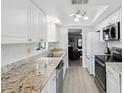 Modern kitchen with white cabinets, granite countertops, stainless steel appliances, and a bright, airy atmosphere at 7360 Ulmerton Rd # 18A, Largo, FL 33771