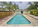 Private backyard pool with patio, surrounded by a wooden fence and tropical foliage at 8020 24Th Ave N, St Petersburg, FL 33710