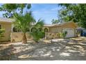 Single-story home with tropical landscaping, unique exterior details and a two-car garage at 8020 28Th N Ave, St Petersburg, FL 33710