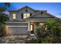 A two-story home exterior is beautifully illuminated at twilight, accentuating its modern design with a lovely yard at 8095 35Th Ave N, St Petersburg, FL 33710