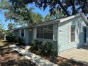 Quaint home with light blue siding and manicured bushes lining the front pathway at 8618 N Orangeview Ave, Tampa, FL 33617