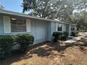 A cozy home featuring light blue siding, trimmed bushes, and a stone pathway at 8618 N Orangeview Ave, Tampa, FL 33617