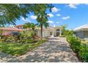 Charming home with lush landscaping, brick driveway, and inviting facade at 8708 Laurel N Dr, Pinellas Park, FL 33782