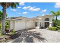Beautiful home showcasing a two-car garage, paver driveway, manicured landscaping, and a light-colored exterior finish at 8708 Laurel N Dr, Pinellas Park, FL 33782
