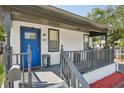 Inviting front porch features a bright blue door, gray railings and modern decor at 909 E 28Th Ave, Tampa, FL 33605