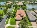 Beautiful aerial view of the home and community, including a lake and lush landscaping at 16227 Cape Coral Dr, Wimauma, FL 33598