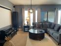 Comfortable living room with neutral tones, a sectional sofa, projector screen, and stylish decor at 10713 Shady Preserve Dr, Riverview, FL 33579