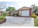 Attractive single-story home featuring a garage and nicely landscaped front yard at 10841 Casa Grande Ave, Port Richey, FL 34668