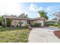 Inviting single-story home featuring a well-manicured lawn and charming curb appeal at 10841 Casa Grande Ave, Port Richey, FL 34668