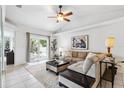 Inviting living room featuring neutral colors, plush seating, a ceiling fan, and sliding glass doors to the backyard at 11510 92Nd Way, Largo, FL 33773