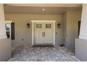 Close-up of the beautiful double front doors and porch with brick pavers and exterior sconces at 12090 Thames Ave, Weeki Wachee, FL 34614