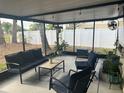 Inviting screened patio with cozy seating, potted plants, and a fan, ideal for outdoor relaxation at 12838 Tallowood Dr, Riverview, FL 33579