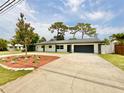 Inviting single-story home with a well-maintained lawn and a paved driveway at 1290 Michigan Blvd, Dunedin, FL 34698