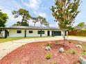 Charming single-story home featuring a well-manicured front yard and attached garage at 1290 Michigan Blvd, Dunedin, FL 34698