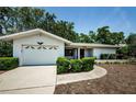 Inviting one-story home with a well-maintained lawn and an attached garage at 1648 Concord St, Dunedin, FL 34698