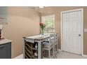 A charming dining area featuring a wooden table set for two near a window and a white door at 1720 Fruitridge St, Brandon, FL 33510