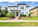 Charming two-story home with manicured lawn, landscaping, and a welcoming covered front porch at 17589 Cruiser Bnd, Land O Lakes, FL 34638
