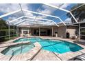 Inviting screened-in pool with a jacuzzi and spacious patio and beautiful blue water at 18518 Bittern Ave, Lutz, FL 33558