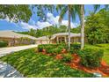 Beautiful single-story home with a well-manicured lawn and mature trees at 1877 Muirfield Way, Oldsmar, FL 34677